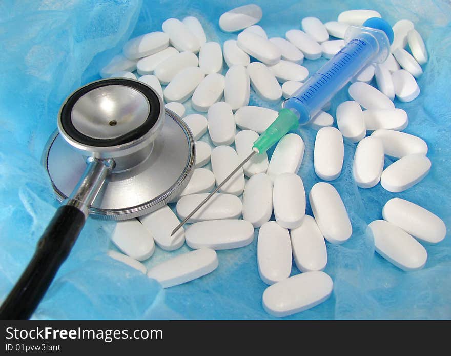 Stethoscope and pills in isolated on blue. Stethoscope and pills in isolated on blue