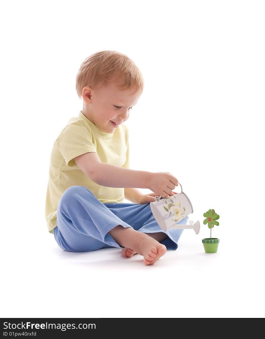 Portrait of adorable happy boy using watering-pot want to water artificial wooden flower. Portrait of adorable happy boy using watering-pot want to water artificial wooden flower