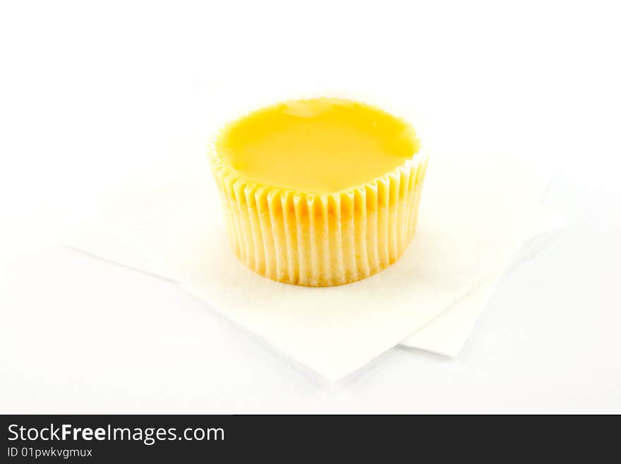 Delicious looking cup cake resting on two white napkins on a plain background