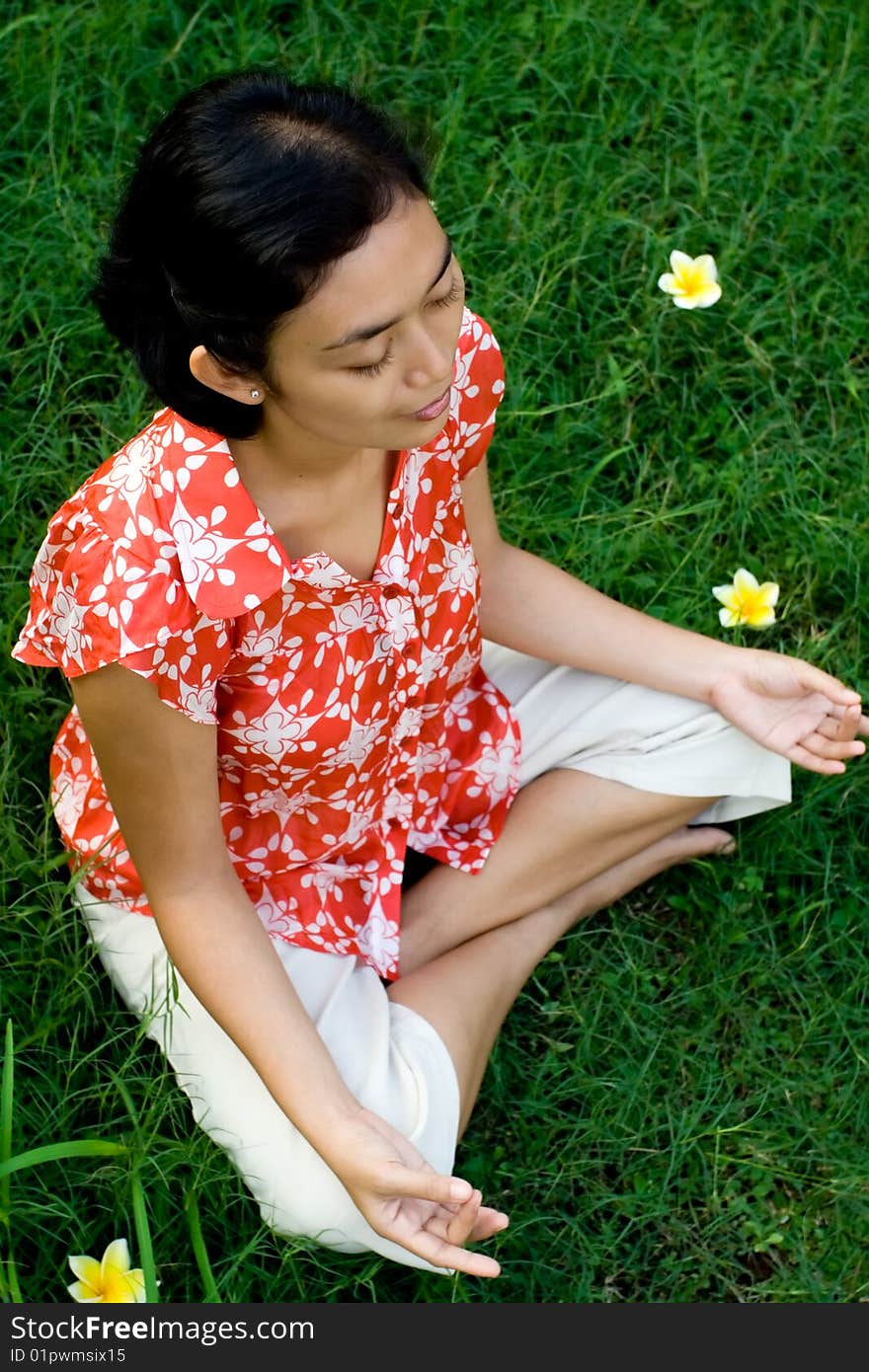 Pretty asian young woman meditating in a green environment. Pretty asian young woman meditating in a green environment