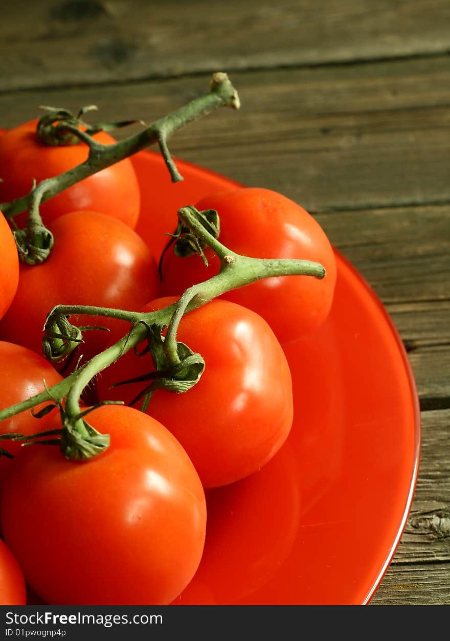 Tomatoes on a red plate on wooden