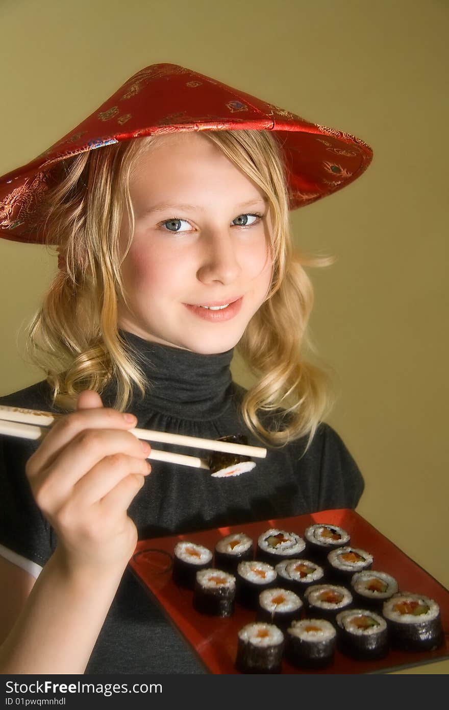 A 13 years old girl with a sushi platter and chopsticks. A 13 years old girl with a sushi platter and chopsticks