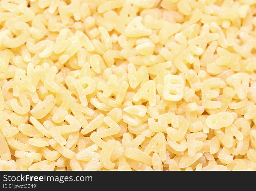 A macro shot of alphabet noodles, with the word alphabet spelled out.