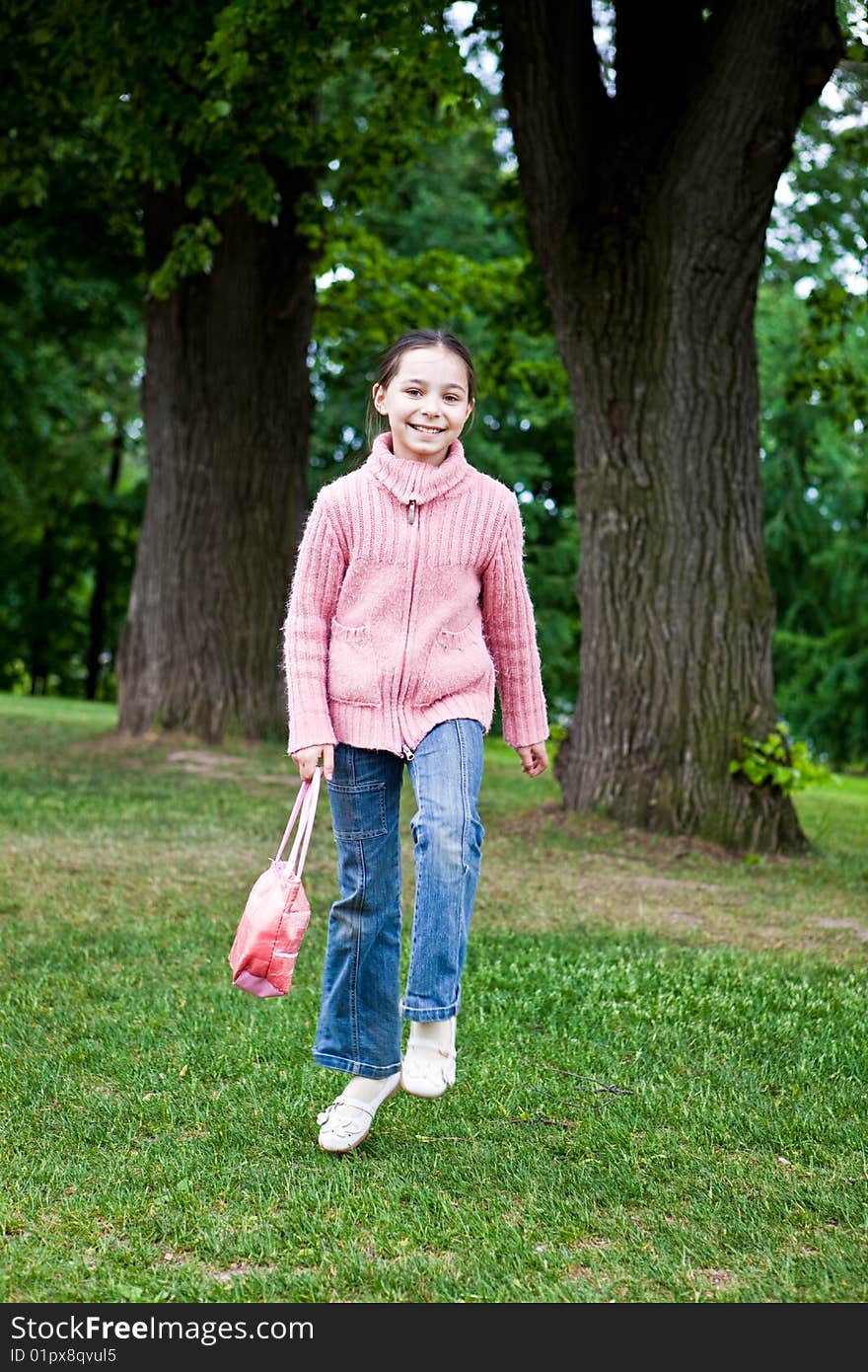 Girl jumps on a green grass against trees. Girl jumps on a green grass against trees