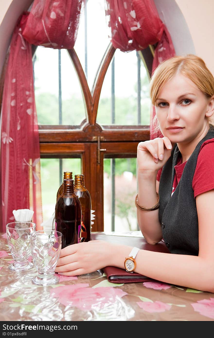 Girl sits in cosy cafe at a window