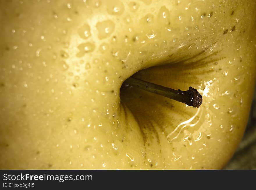 Close up shot of a yellow apple with some drops of water