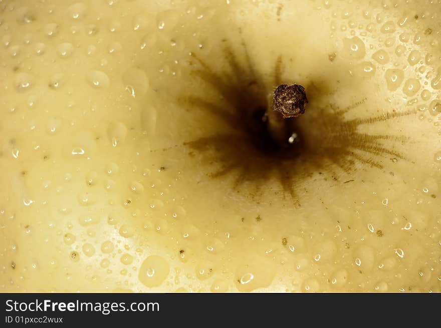 Close up shot of a yellow apple with some drops of water