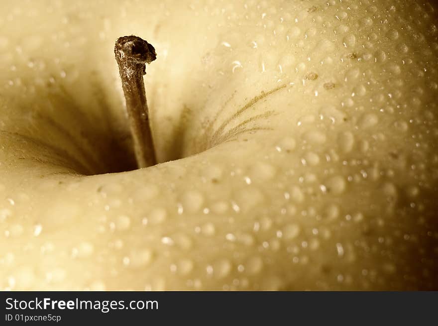 Close up shot of a yellow apple with some drops of water