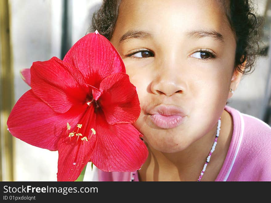 A brown girl with a red flower. A brown girl with a red flower