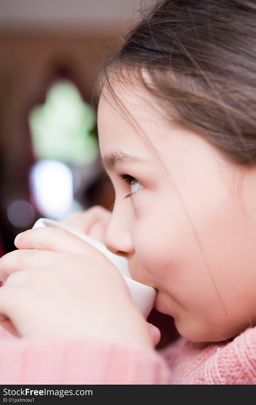 Girl drinks from a white cup