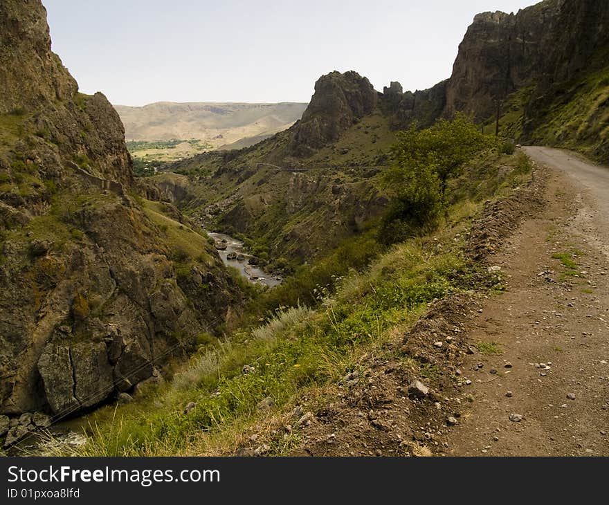 Narrow mountain path, River in valley. Summer day in Georgia. Caucasus