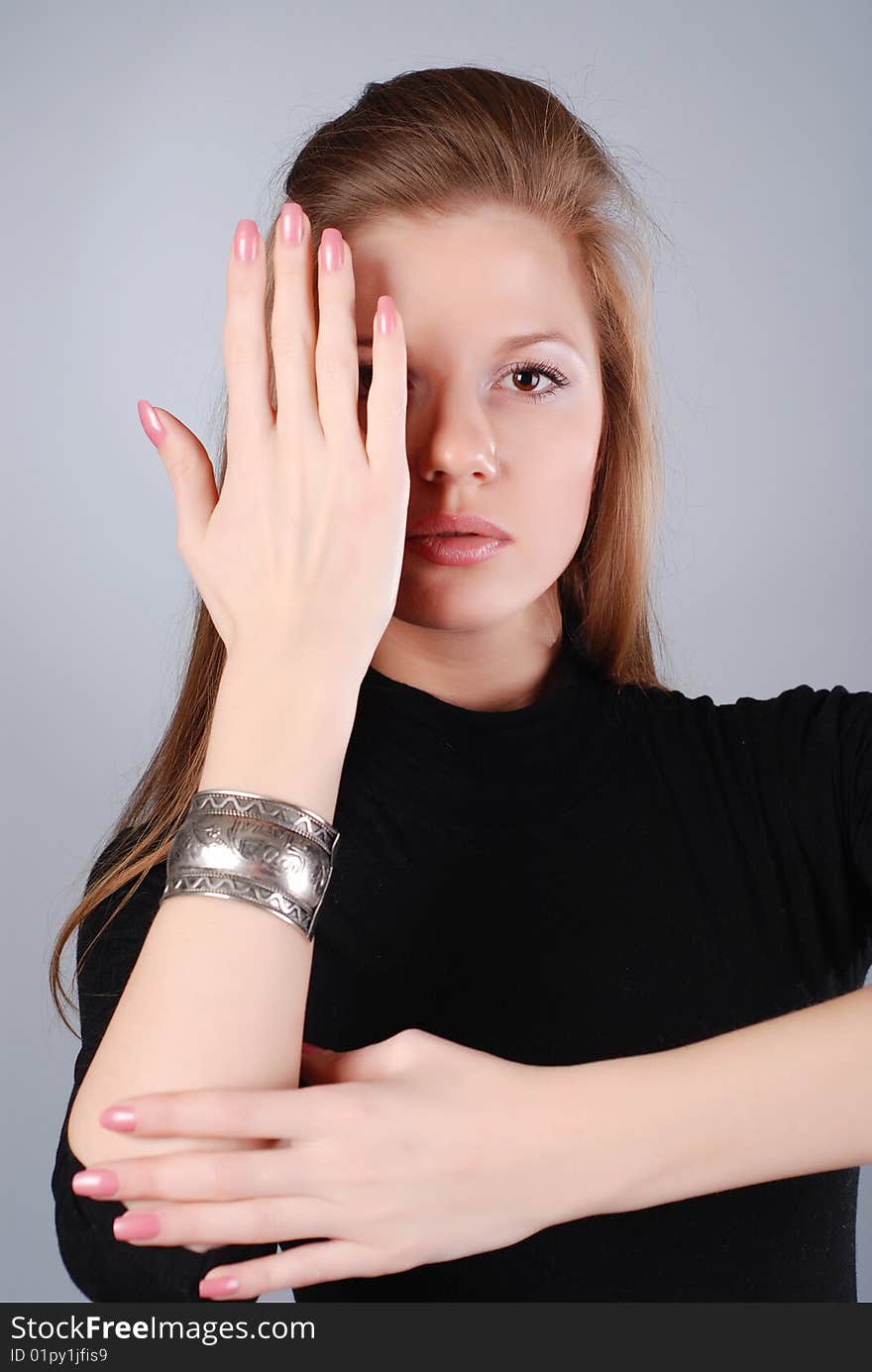 Portrait of young beautiful woman at grey background