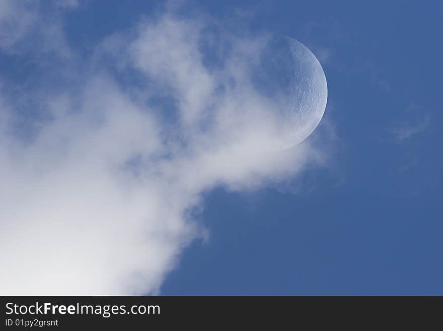 Landscape with moon in day sky with clouds