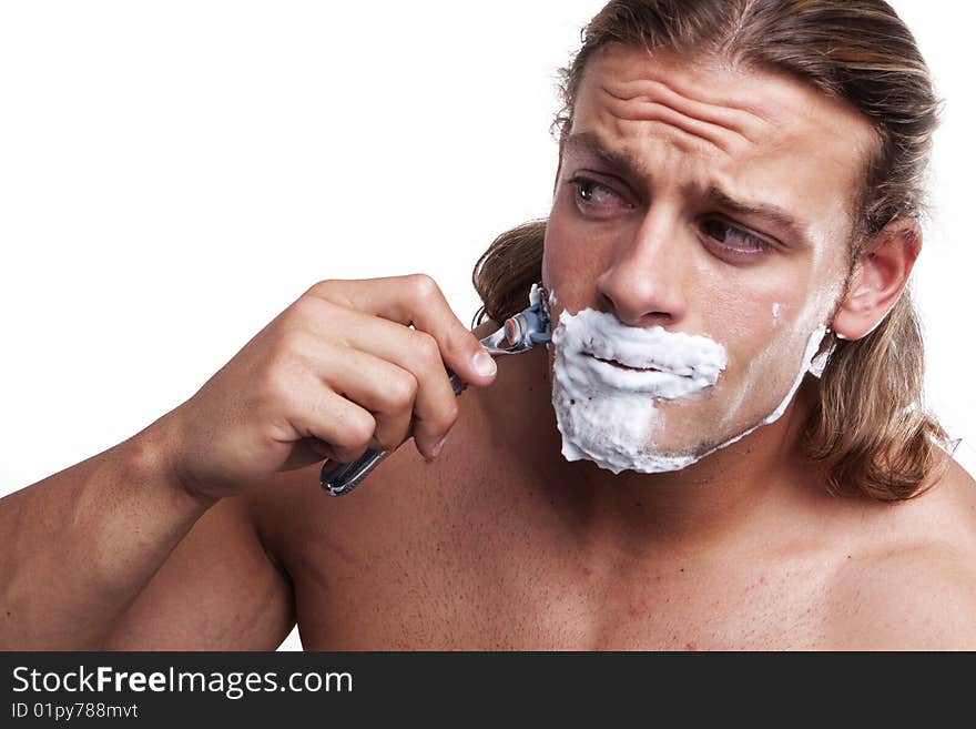 Portrait of a young handsome man shaving as part of his morning routine. Portrait of a young handsome man shaving as part of his morning routine.