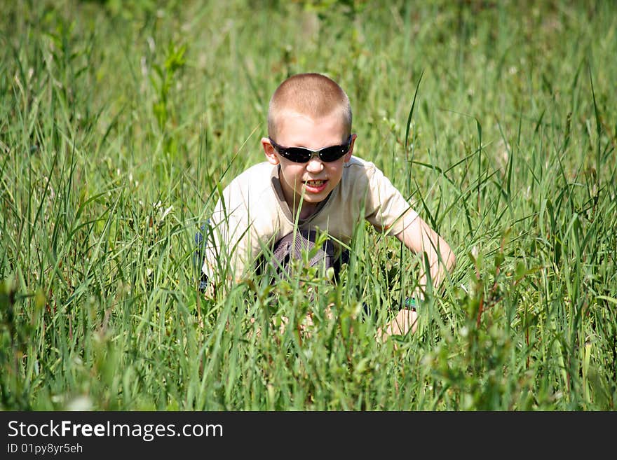 The boy in a grass on the nature plays security service