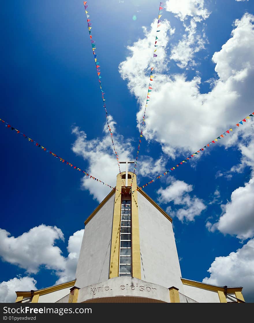 Modern Catholic church decorated with multi-coloured flags for a holiday