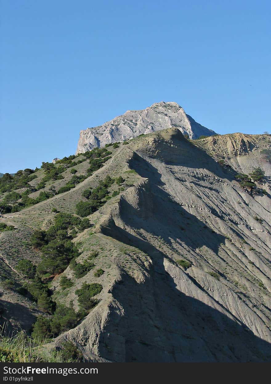 Mountain range passing in blue sky. Crimea.