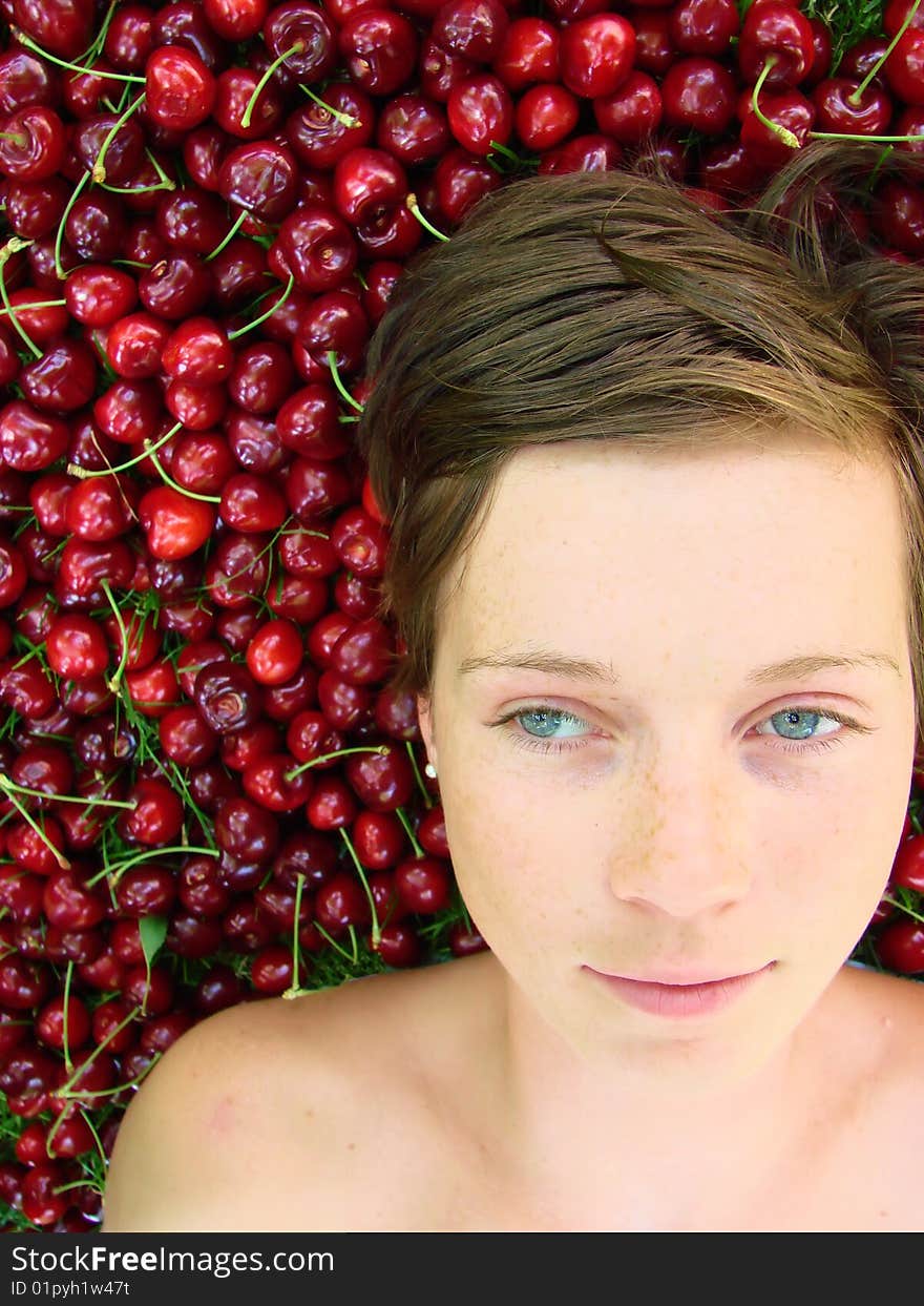 Blue eyed young girl on a bed of cherries. Blue eyed young girl on a bed of cherries