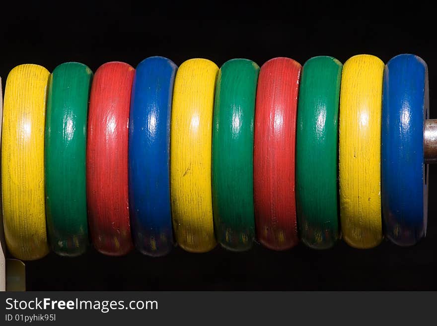 Colour wooden abacus on black background. Toy.