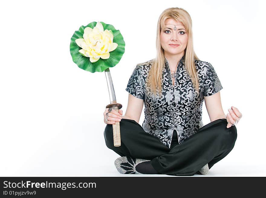 Woman with katana meditating in lotus pose