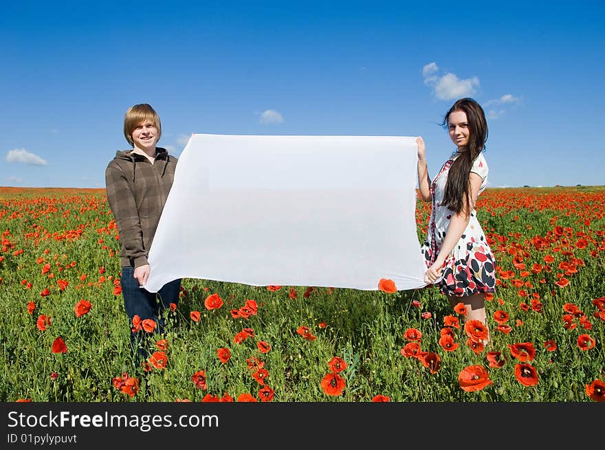 Beautiful couple in the poppy field, copy-space for your text