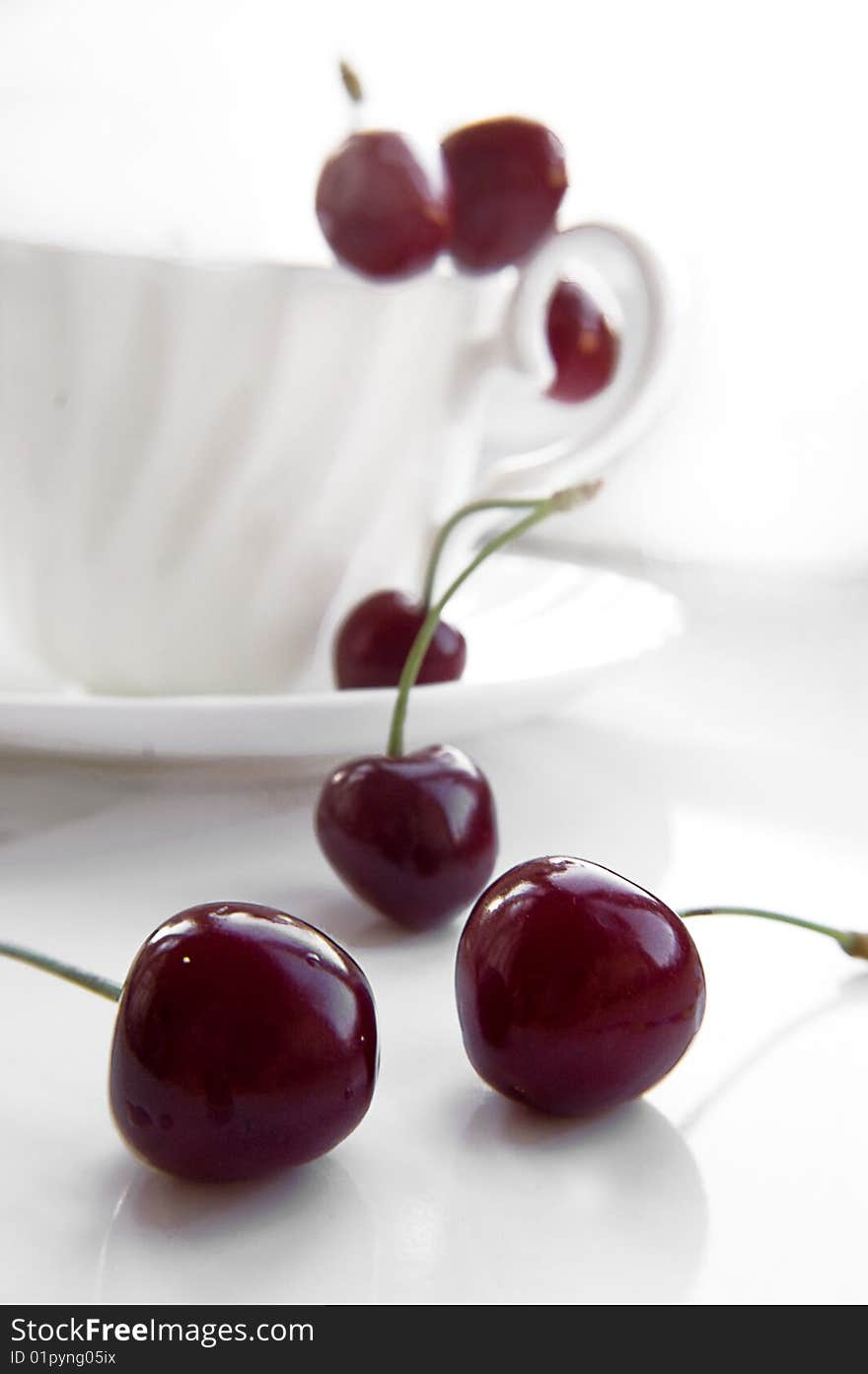 Some cherries in cup over white background