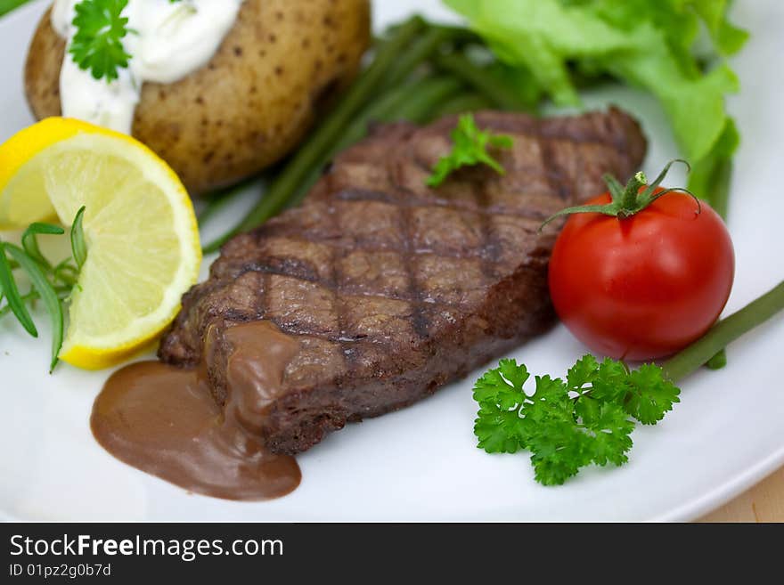 Grilled steak with baked potato and cream.