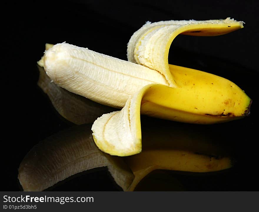 Banana on glass table with refection