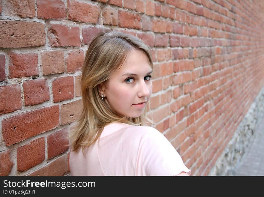 Nice girl near brick wall