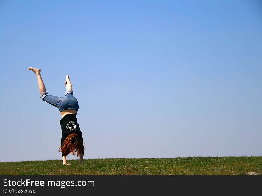 The girl taken in a jump lstanding on the hands. The girl taken in a jump lstanding on the hands