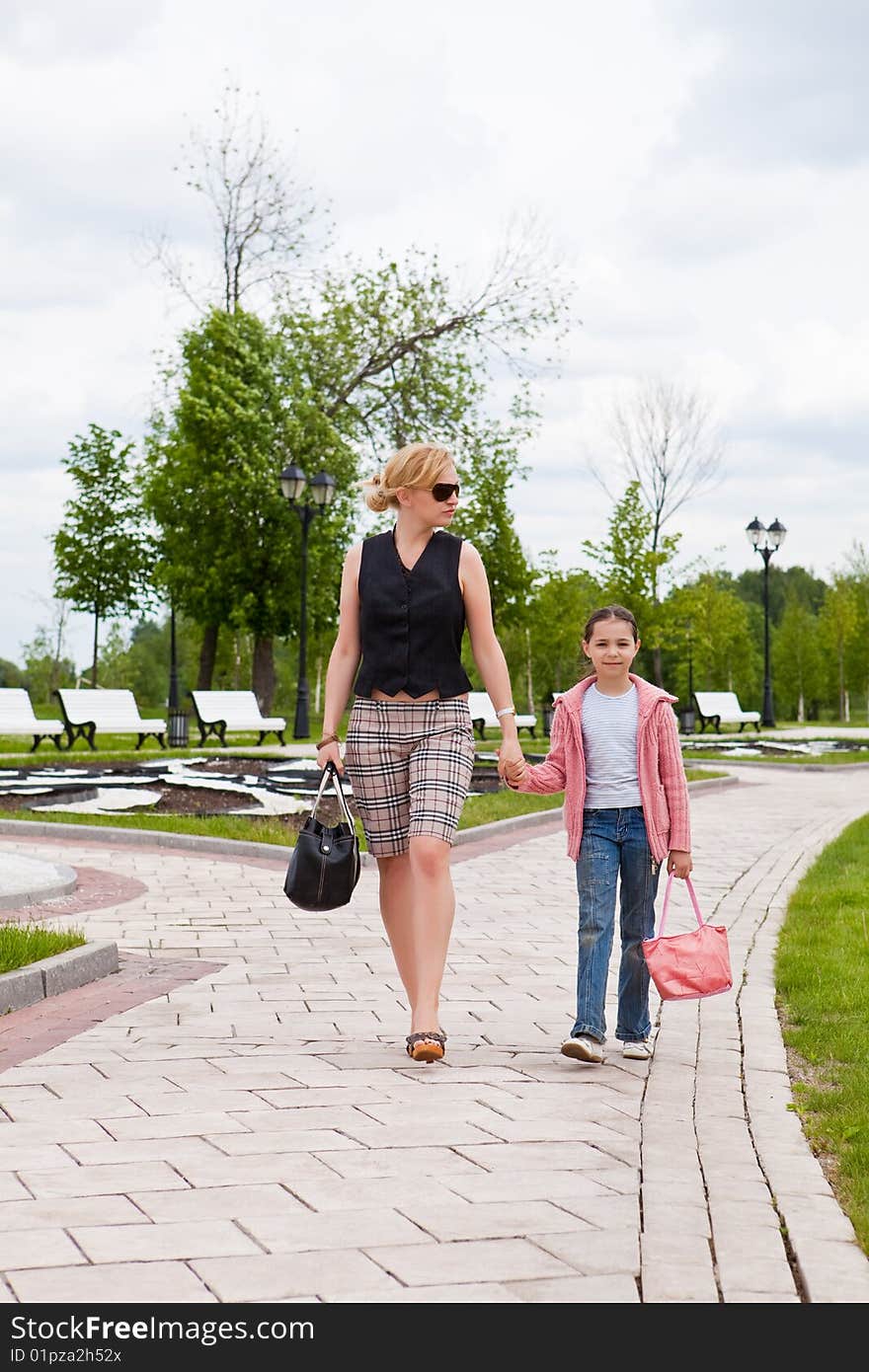 Mother and the daughter walk on a path in park. Mother and the daughter walk on a path in park