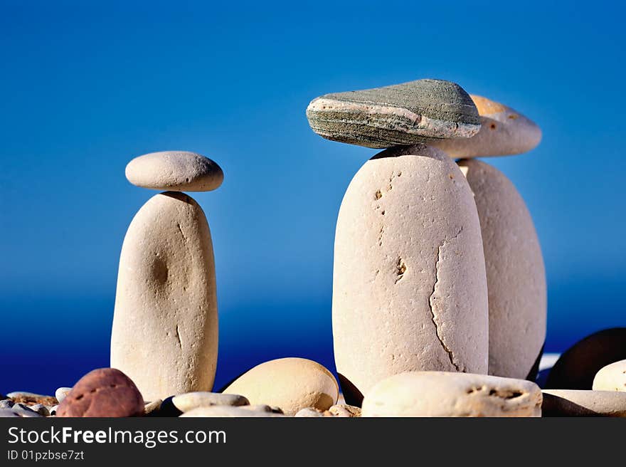 Three long white pebbles on a background of blue sky. Three long white pebbles on a background of blue sky