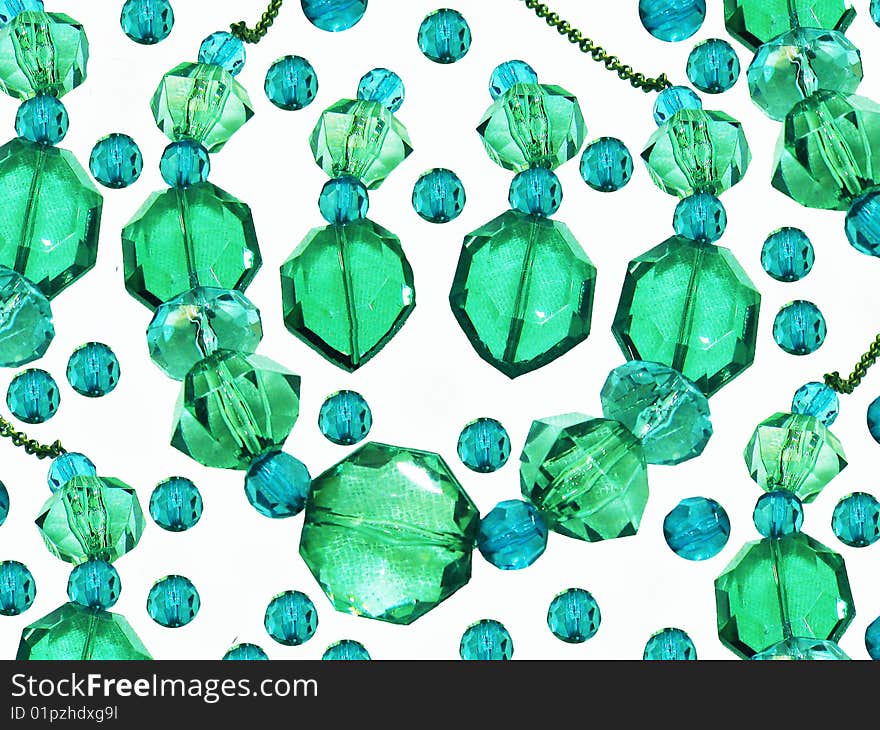 A background of a blue and green gemstone necklace and earrings, with beads surrounding it. A background of a blue and green gemstone necklace and earrings, with beads surrounding it.