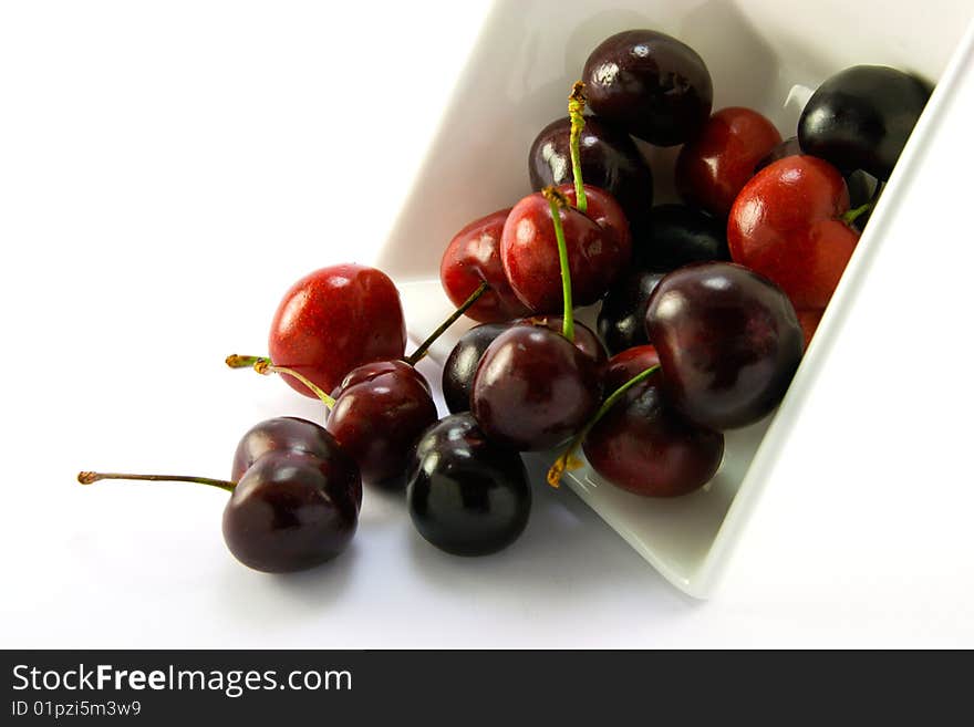 Spilt bowl of cherries with white background with clipping path