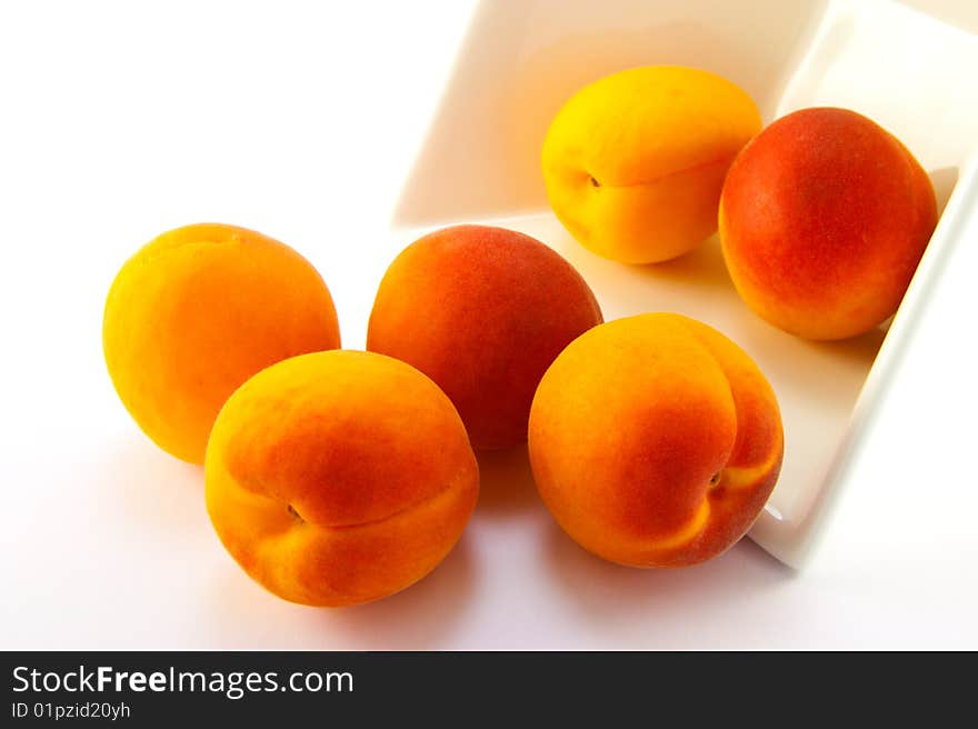 Spilt bowl of apricots with white background with clipping path