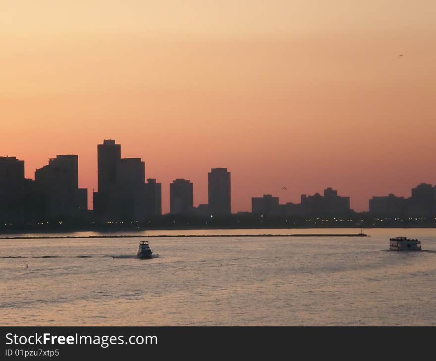 The sun sets over the city and the lake. The sun sets over the city and the lake