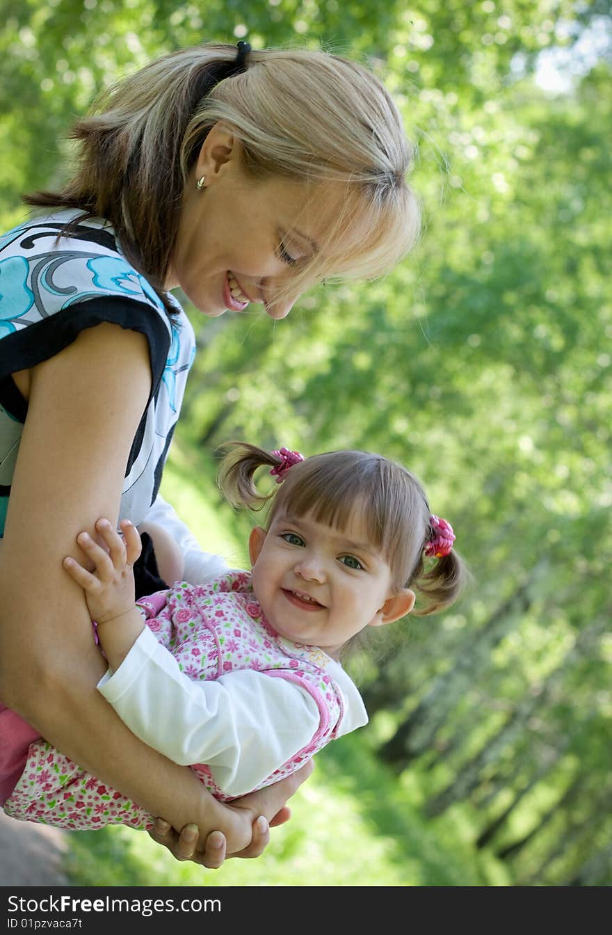 Happy mother and daughter playing outdoor, Summer