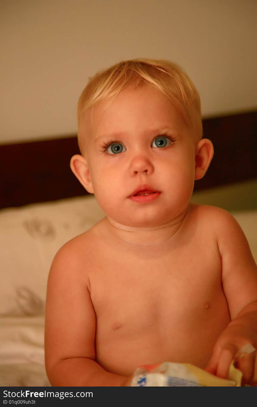 Baby standing in bed after the bath. Baby standing in bed after the bath