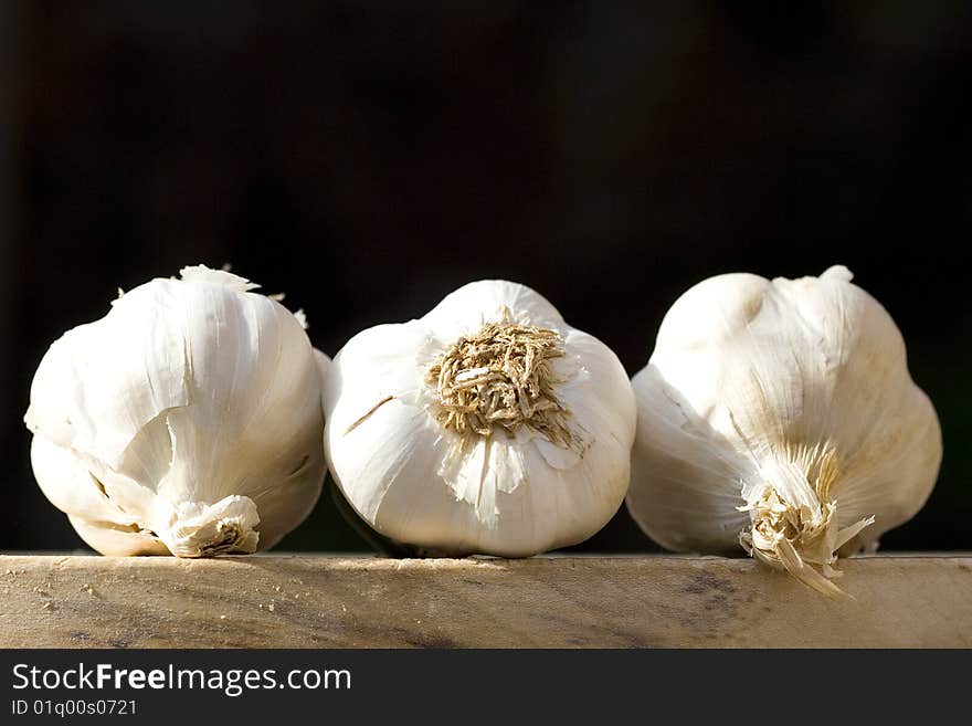 Still life of three garlic on a black background