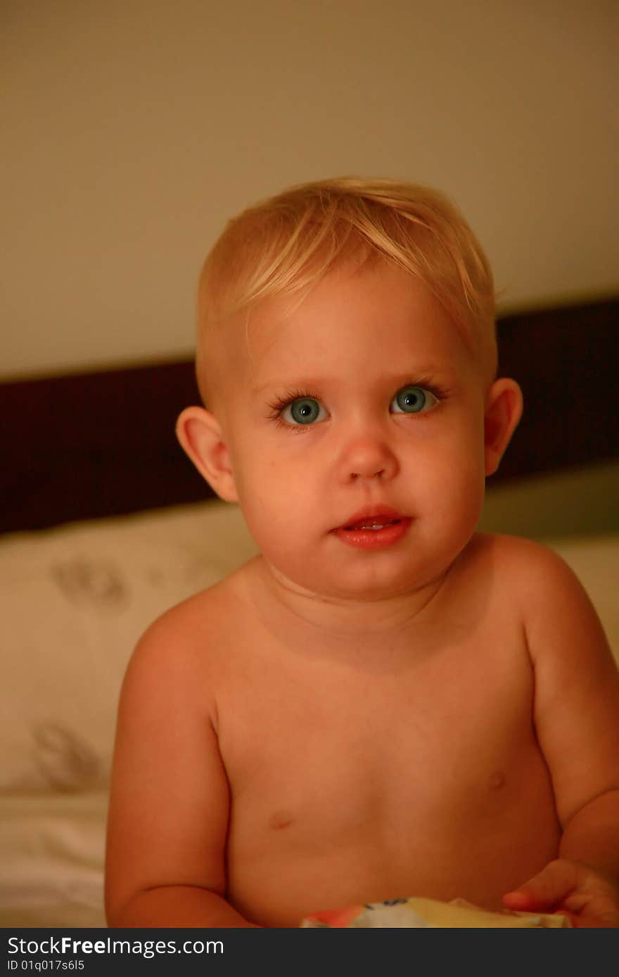 Baby looking up in a bed