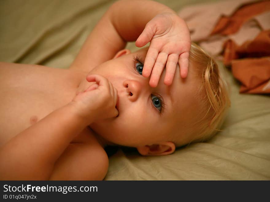 Baby girl hiding behind her hand. Baby girl hiding behind her hand