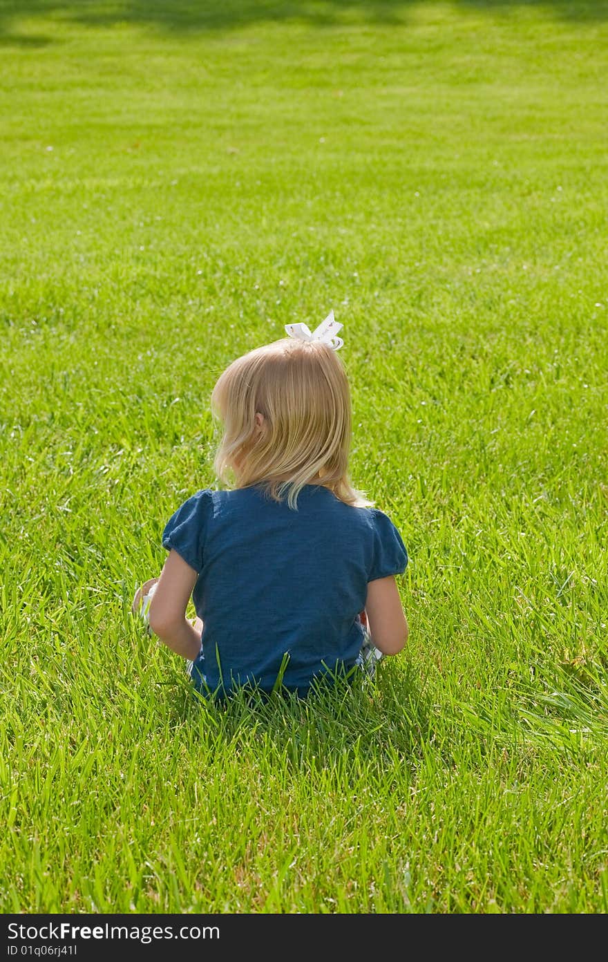 Little girl sitting in grass