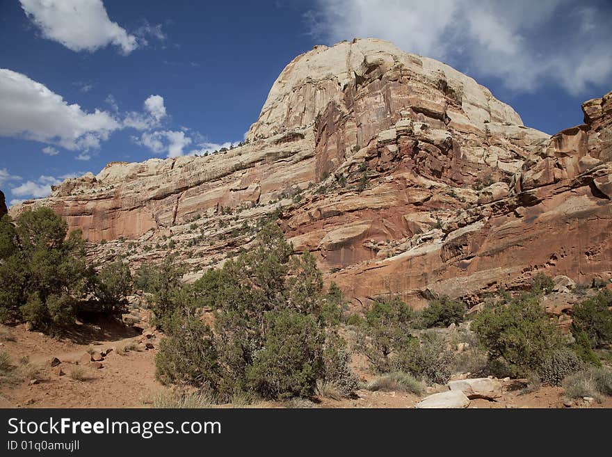 View of red rock formations in Captiol Reef National Park with blue sky�s the and clouds