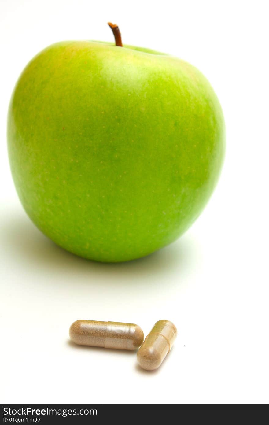 Apple and vitamin capsules on white background. Apple and vitamin capsules on white background