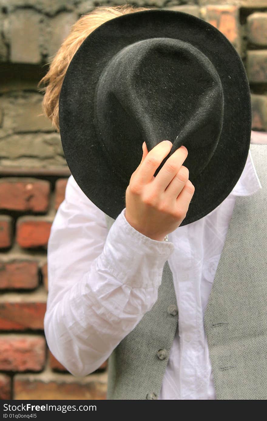 Man with hat posing at the brick wall