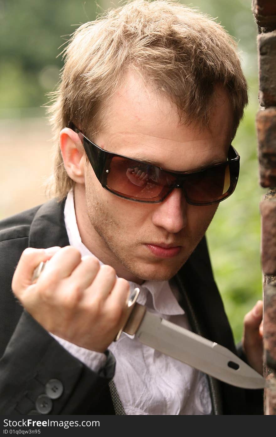 Angry man in sunglasses holding a knife. Angry man in sunglasses holding a knife