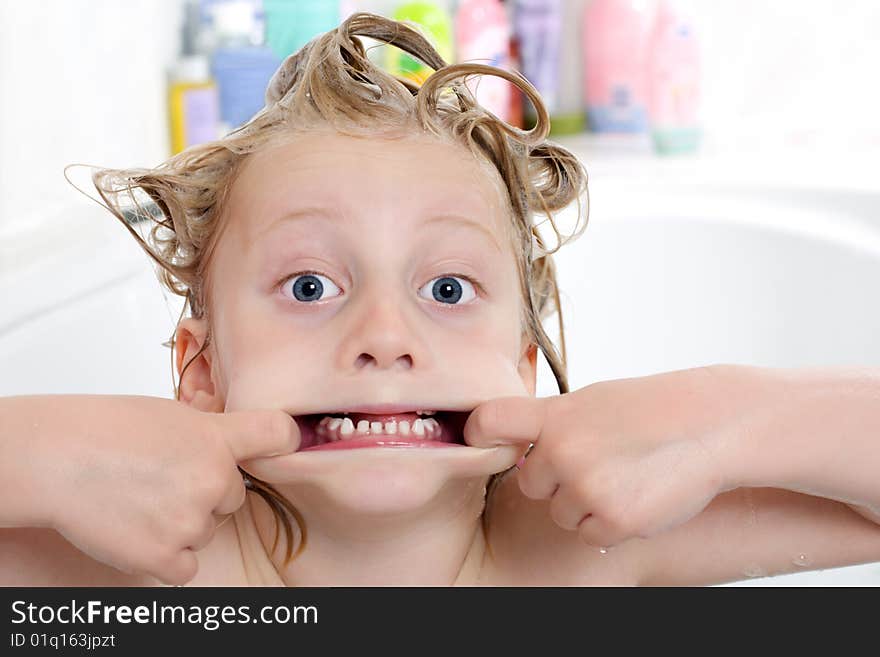 Young child is sitting in bath tub and makes a grimace. Young child is sitting in bath tub and makes a grimace