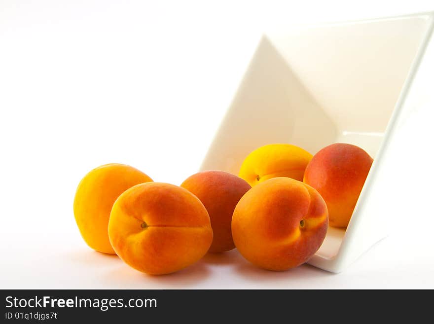 Spilt bowl of apricots with white background with clipping path