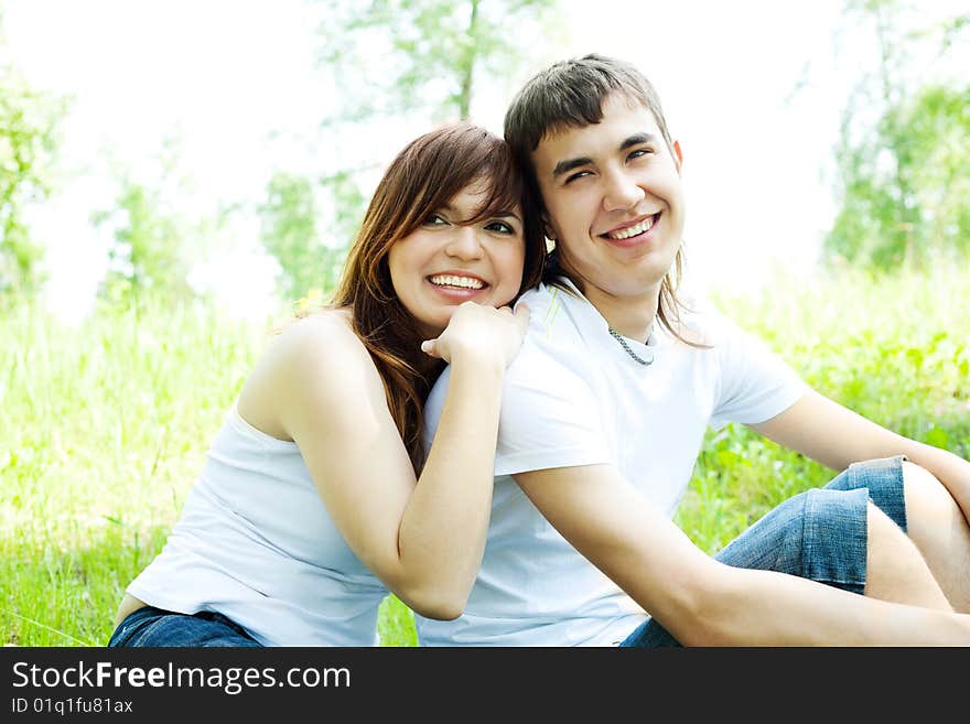 Happy young couple having fun in summer park