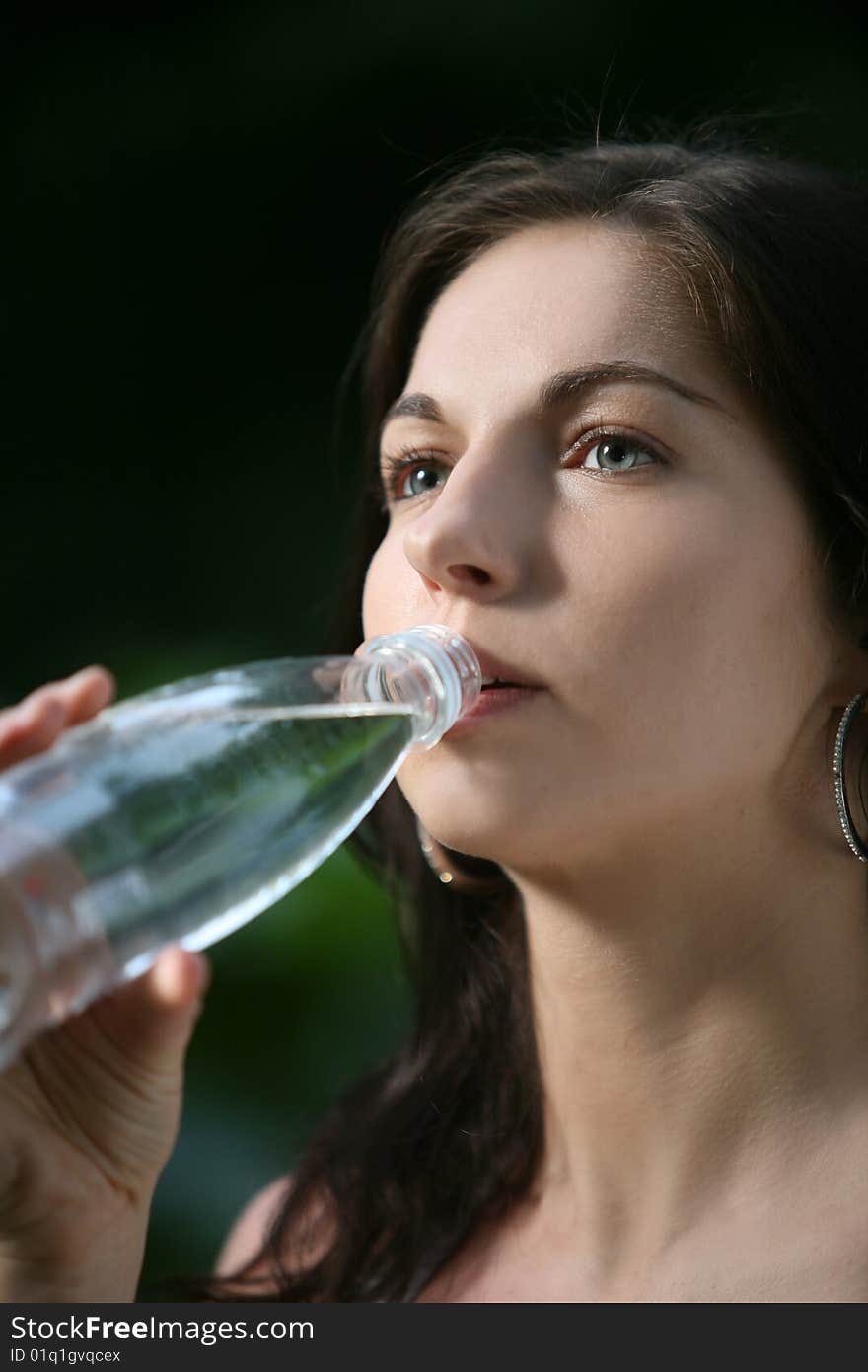 Beautiful young woman in the park. Drinks water. Beautiful young woman in the park. Drinks water.